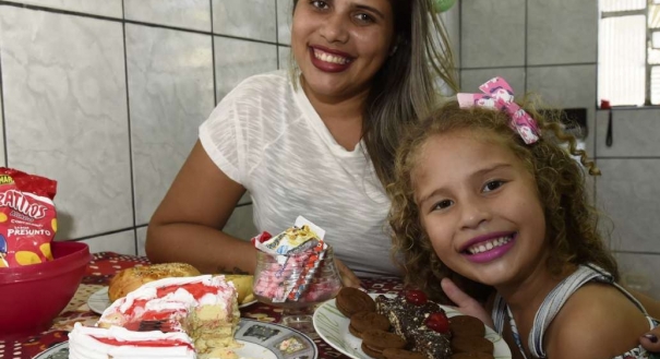 Julia, de 5 anos, pede para a mãe, Sabrina, trocar a comida por biscoitos e bolos