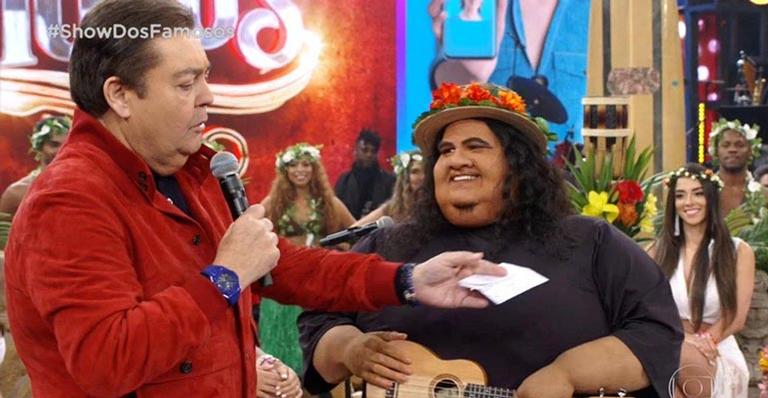 O ator Hugo Bonemer vestido do cantor Israel Kamakawiwo'ole no Show dos Famosos ao lado de Faustão, no Domingão do Faustão. Crédito: TV Globo/Reprodução