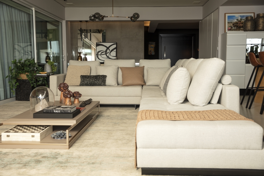 O living tem sofá de linho off white para 12 lugares e almofadas de materiais nobres