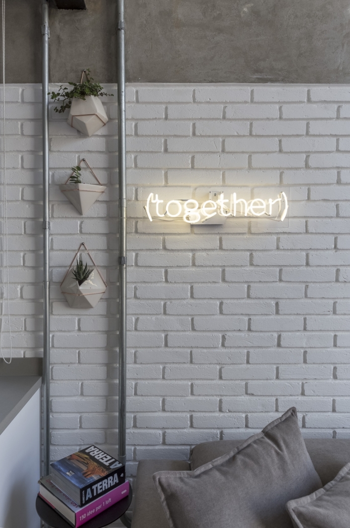 O loft com estilo industrial e base clara, assinado pela arquiteta Carina Korman, do escritório Korman Arquitetos, ganhou plantinhas com vasinhos bem modernos e, ao lado, um letreiro de neon. Um toque sutil para combinar com a nova estação. Crédito: joao paulo s.de oliveira